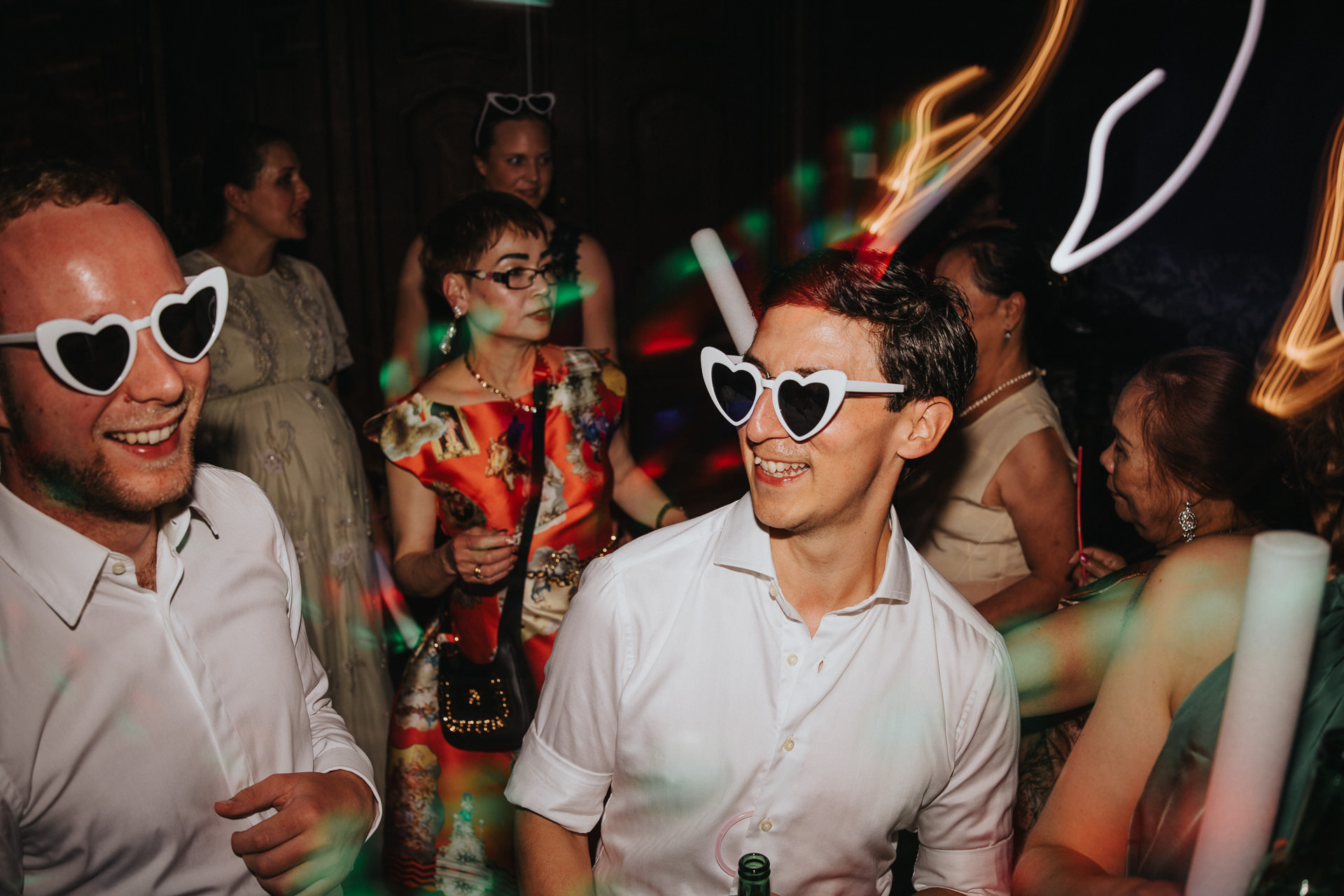 Glada bröllopsgäster dansar tillsammans under en livlig bröllopsfest