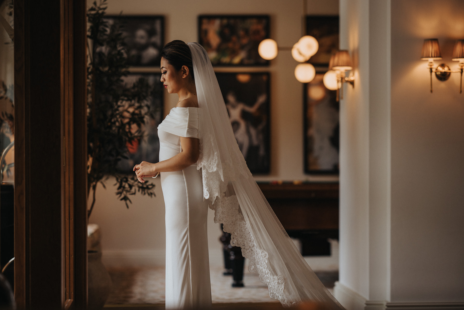 Brud i elegant vit klänning och långt spetsslöja på Maryhill Estate