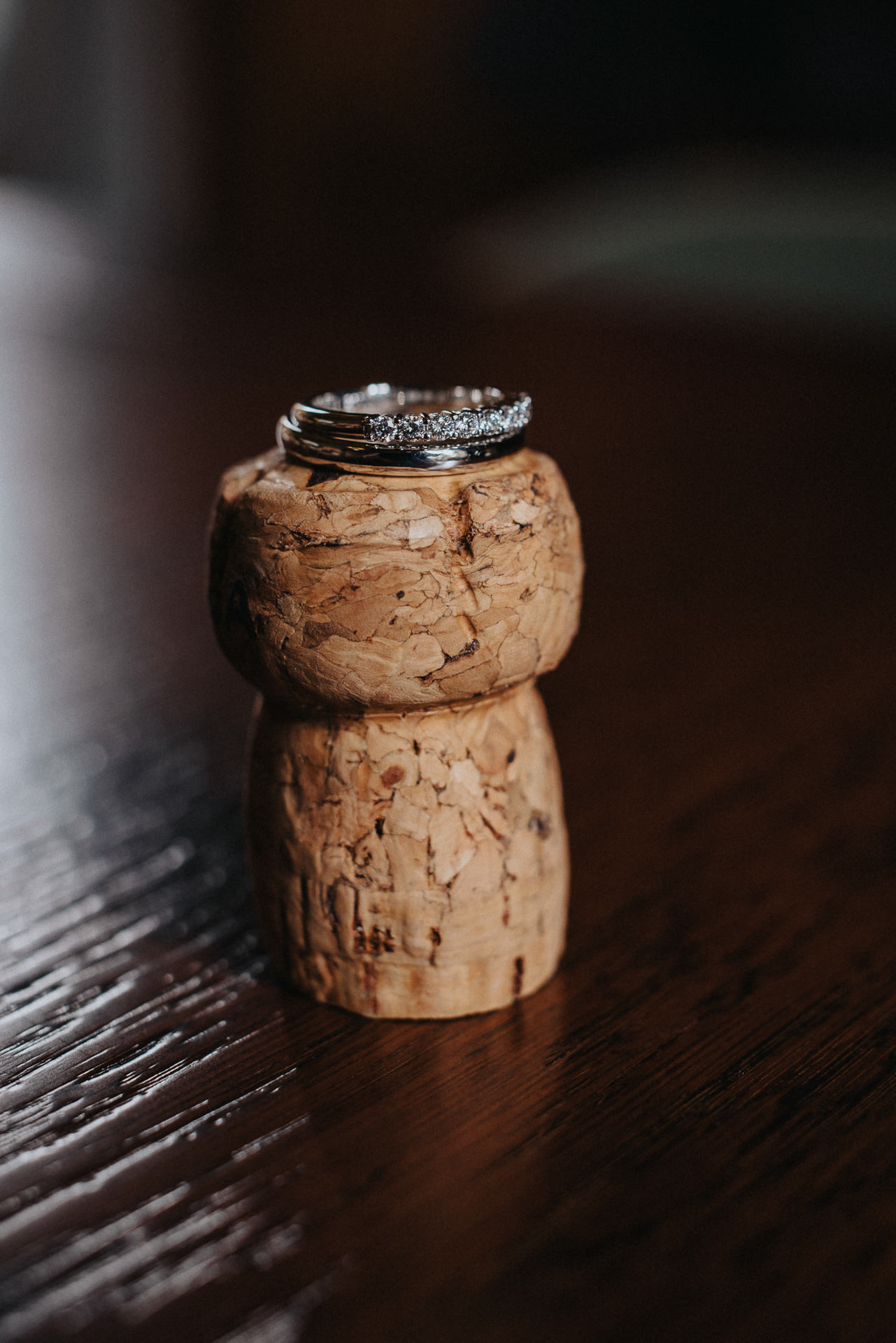 Vigselringar med diamanter placerade på en champagnekork